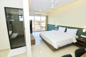 Ένα ή περισσότερα κρεβάτια σε δωμάτιο στο Swarnam Hotel