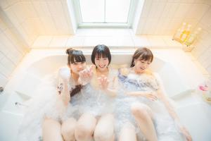 3 jeunes femmes assises dans une baignoire dans l'établissement Hotel & Sweets Fukuoka LOVEHOTEL, à Fukuoka