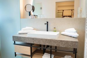 ein Bad mit einem Waschbecken und einem Spiegel in der Unterkunft Hotel Schachner in Maria Taferl