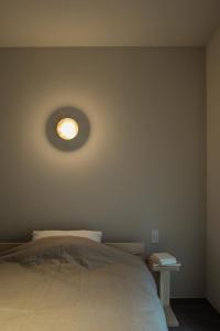 a bedroom with a bed with a light on the wall at SOUQ in Himeji