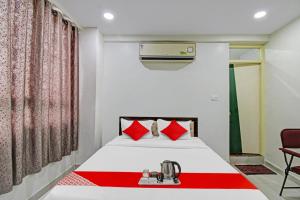 a bedroom with a bed with red pillows at Hotel Sunshine Inn in Nagpur