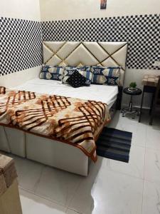 um quarto com uma cama com um edredão e almofadas em Kashi cottage em Varanasi