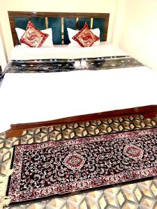 ein Bett mit einem roten und schwarzen Teppich drauf in der Unterkunft Kashi cottage in Varanasi