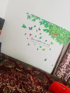 um quarto com uma cama com borboletas na parede em Kashi cottage em Varanasi