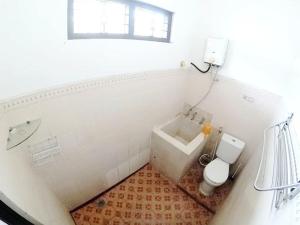 La salle de bains blanche est pourvue de toilettes et d'un lavabo. dans l'établissement Guest House MW 46 by NmRooms, à Demangan