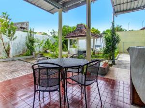 d'une terrasse avec une table et des chaises. dans l'établissement Guest House MW 46 by NmRooms, à Demangan
