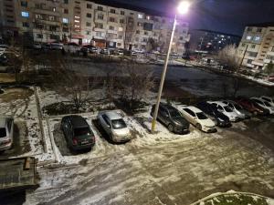 eine Gruppe von Autos, die nachts auf einem Parkplatz geparkt werden in der Unterkunft 2-х комнатная квартира рядом с Толе би in Taras