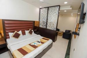 1 dormitorio con 1 cama con cabecero de madera en Premium Inn near Sector 15 metro station, en Noida