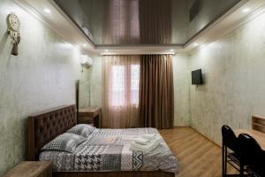 a bedroom with a bed and a table and a window at Holiday Home Data in Batumi