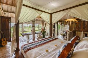 a bedroom with a large bed in a room at The Rice Joglo Eco-Stay in Ubud