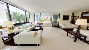 a living room with white furniture and large windows at Jamaica Punta del Este Hotel & Residence in Punta del Este