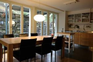 una cucina e una sala da pranzo con tavolo e sedie in legno di Erica a Spiez