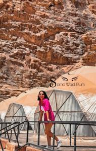 a woman is standing in front of a tent at Sama Wadi Rum in Wadi Rum