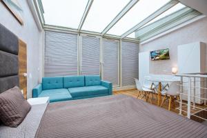 a bedroom with a blue couch and a table at Apartament nad morzem in Władysławowo