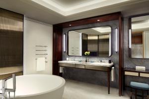 a bathroom with a tub and a large mirror at The St. Regis Qingdao in Qingdao