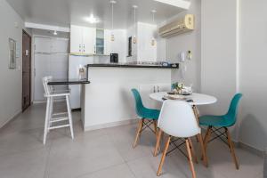 - une cuisine et une salle à manger avec une table et des chaises dans l'établissement Loft equipado, ótimo wi-fi, na beira da Prainha, à Arraial do Cabo