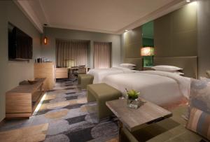 a hotel room with two beds and a kitchen at Sheraton Hsinchu Hotel in Zhubei