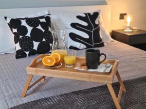 a tray of orange juice and orange slices on a bed at Glam House Assemini in Assemini