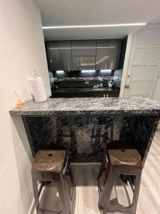 a kitchen with a counter with two stools in it at Kevin Apartamento Moderno en Cali in Cali