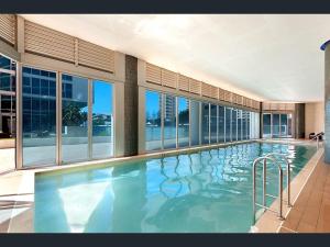 a large swimming pool in a building with windows at H-Residences Private Apartments - Hosted by Coastal Letting in Gold Coast