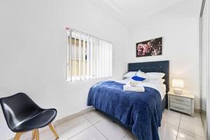 een slaapkamer met een bed en een stoel erin bij Cozy 4 Bedroom House at Prime Location in Sydney