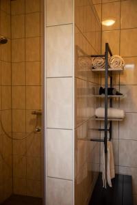 un bagno con doccia e asciugamani su una mensola di Tussen Heide en Bos a Opglabbeek