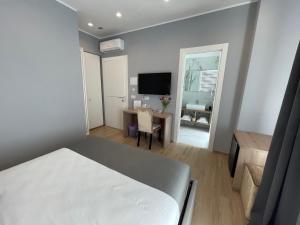 um quarto com uma cama, uma secretária e uma televisão em Martini Suite 2 Bari em Bari