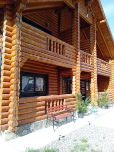 un edificio de madera con un banco delante de él en Casa Ilies, en Rozavlea