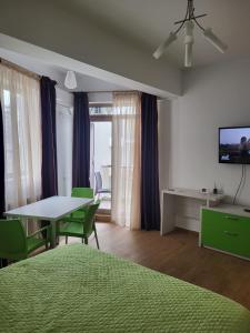 a bedroom with a bed and a table with chairs at Premier Apartaments by Twin Residence in Mamaia