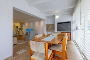 uma sala de jantar com uma mesa de madeira e cadeiras em The Waterfront Cottage F3 em Swakopmund