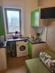 a small kitchen with a washing machine and a sink at Premier Apartaments by Twin Residence in Mamaia