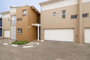 a house with two garage doors in a driveway at The Waterfront Cottage F3 in Swakopmund