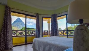a bedroom with a bed and a view of a mountain at Sea Piton View Apartment- Location, Convenience, Modern Living in Soufri&egrave;re