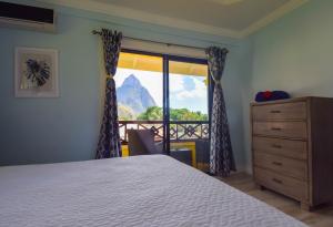 una camera da letto con un letto e una finestra con vista di Sea Piton View Apartment- Location, Convenience, Modern Living a Soufriere