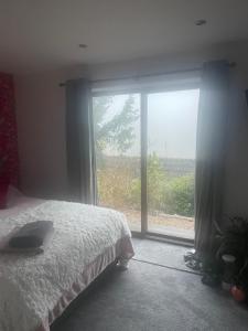 a bedroom with a bed and a large window at The Croft Accommodation in Gamrie
