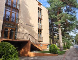 a building with a staircase on the side of it at Tarp Pušų - Jaukūs apartamentai - 15 min iki jūros in Palanga