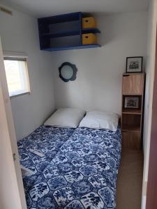 1 dormitorio con 1 cama con edredón azul y blanco en Mobilhome cosy au calme de la campagne, en Lombez