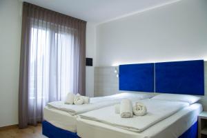 A bed or beds in a room at Liz Hotel & Apartments