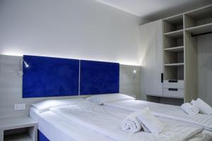 A bed or beds in a room at Liz Hotel & Apartments