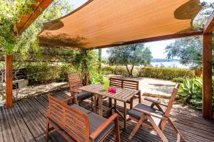 a wooden table and chairs on a wooden deck at Villa Demiana by Ezoria Villas in Coral Bay