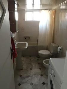 La salle de bains est pourvue de toilettes, d'un lavabo et d'un lave-linge. dans l'établissement Sunrise View Apartment, à Chios