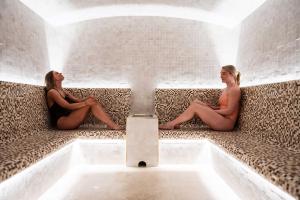 Due donne sedute nella vasca da bagno in una stanza di Sundvolden Hotel a Sundvollen