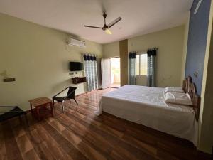 a bedroom with a bed and a table and a chair at PVRR HILL VIEW RESORTS, NEAR HORSLEY HILLS Road in Kurabalakota