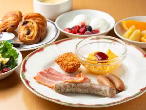 een tafel met borden ontbijtproducten en zoete deegwaren bij Iwaki Washington Hotel in Iwaki