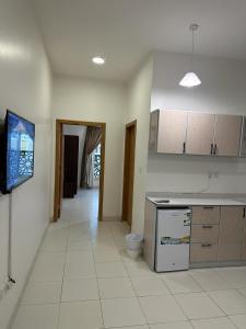 a kitchen with a counter and a tv on the wall at دبليو تاون للشقق المخدومة - W Town Serviced Apartments in Jeddah