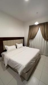 a large white bed in a room with a window at دبليو تاون للشقق المخدومة - W Town Serviced Apartments in Jeddah