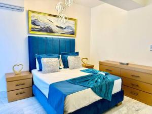um quarto com uma cama e armários azuis e brancos em Wendy Luxury Tower em Santiago de los Caballeros