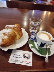 a table with a cup of coffee and a croissant at B&B Villa Martina in Sardara