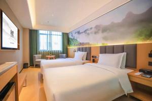 a hotel room with two beds and a tv at True Go Hotel - Shenzhen Futian Huaqiang North in Shenzhen