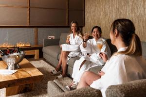 Trzy kobiety siedzące w salonie pijące szampana w obiekcie Sundvolden Hotel w mieście Sundvollen